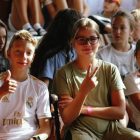 Cheerful group of children sitting together at an indoor event, showcasing friendships and diversity.